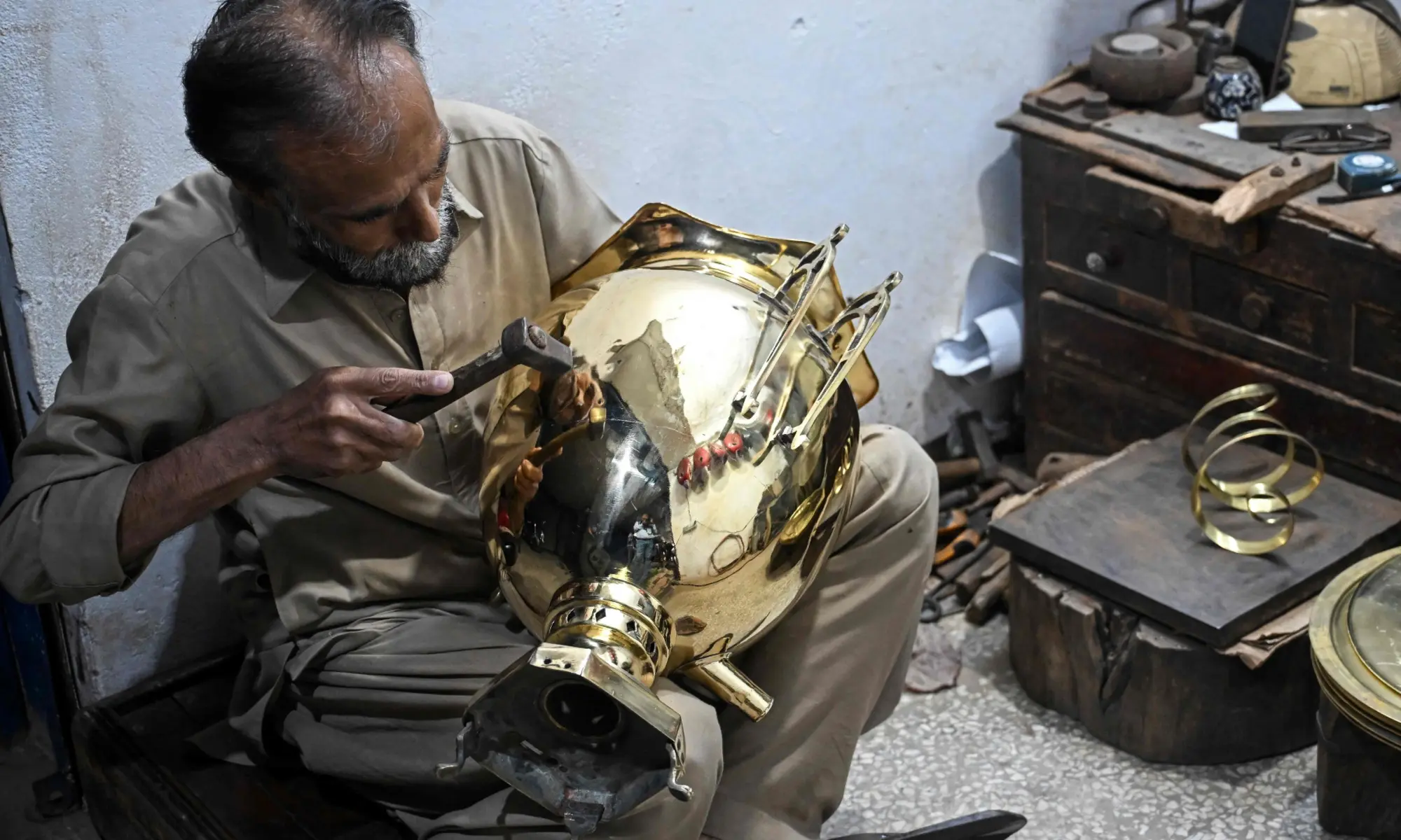 Antique dealer Shakeel Ahmed works on an artefact at his restoration workshop in Rawalpindi on October 20, 2026. &mdash;AFP