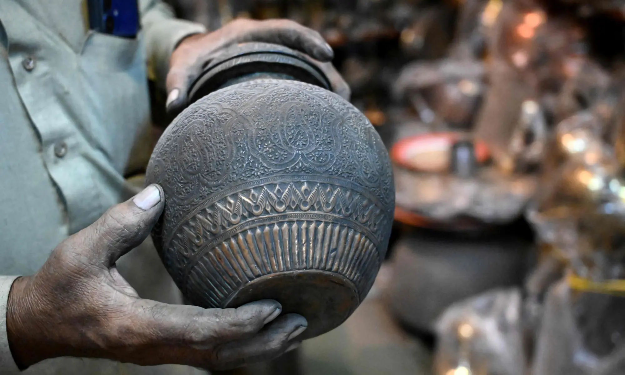Antique dealer Ahsan Shakeel shows an artefact at his shop selling vintage items in Rawalpindi on October 20, 2026. &mdash;AFP