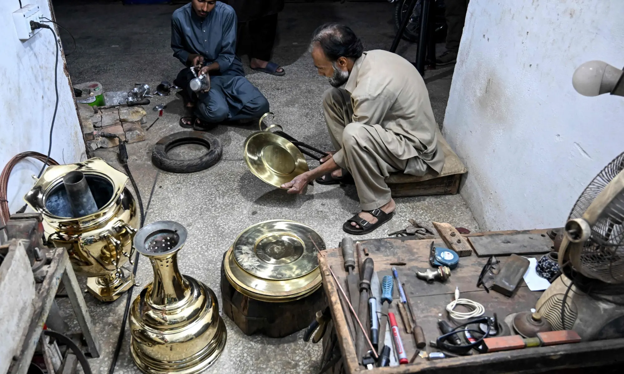 Antique dealer Shakeel Ahmed works on an artefact at his restoration workshop in Rawalpindi on October 20, 2026. &mdash;AFP