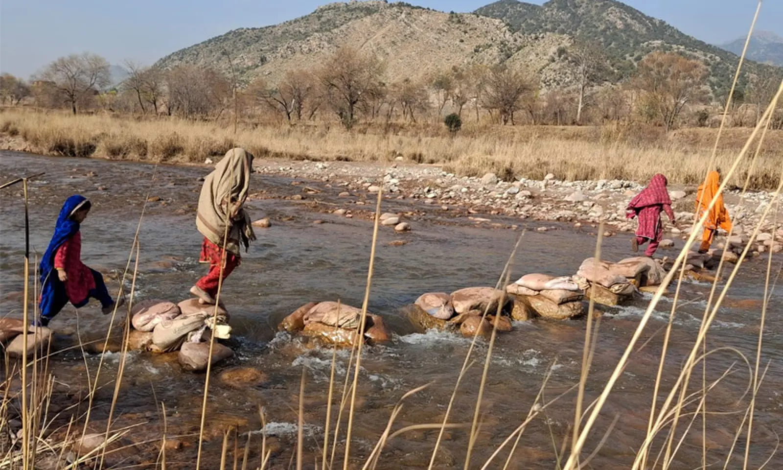Girls jump over stepping stones to cross the Bara River in Tirah Valley, Khyber district. — Dawn Girls jump over stepping stones to cross the Bara River in Tirah Valley, Khyber district. — Dawn