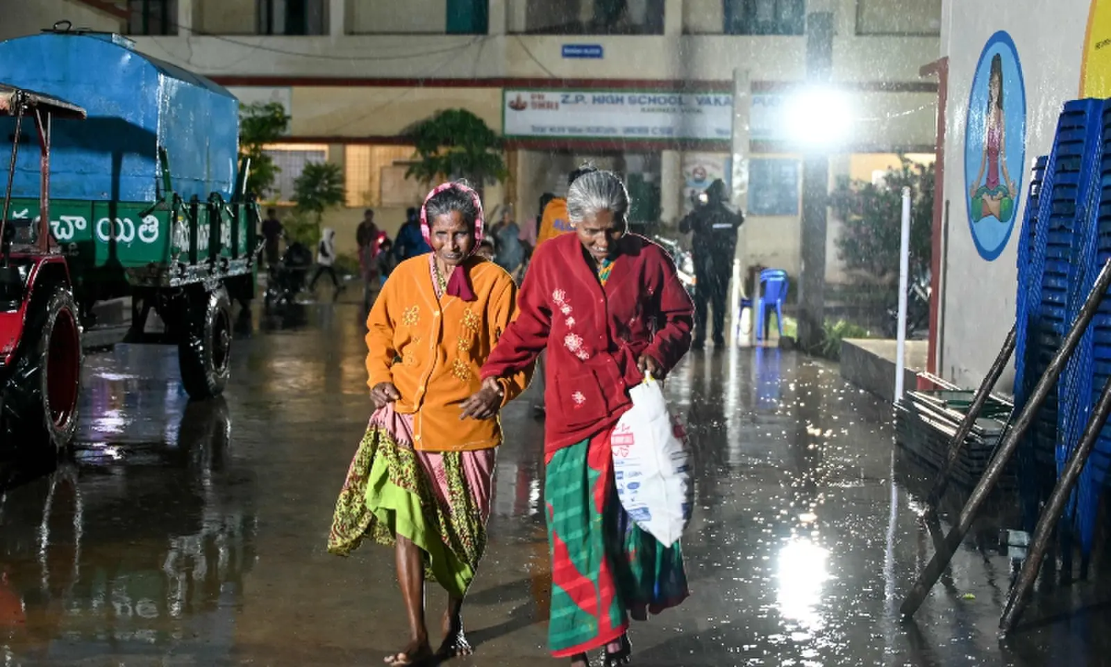 Fishing community members arrive at a relief shelter during rainfall in Andhra Pradesh's Kakinada on October 27, 2026 ahead of cyclone Arnab's expected landfall. &mdash;AFP