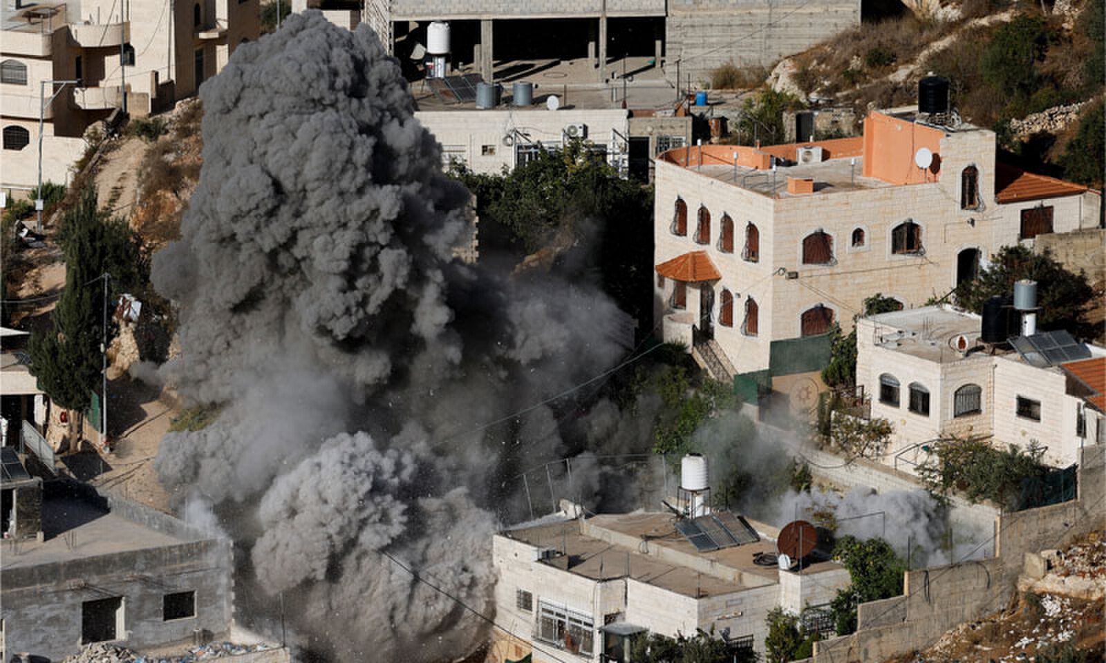 SMOKE rises after an explosion as the Israeli army demolishes the home of a Palestinian in the occupied West Bank.—Reuters SMOKE rises after an explosion as the Israeli army demolishes the home of a Palestinian in the occupied West Bank.—Reuters