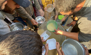 PHOTOS: Palestinians line up for soup as Israeli bombardment resumes