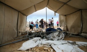 PHOTOS: Palestinians inspect damage at site of Israeli strike on Gaza shelter