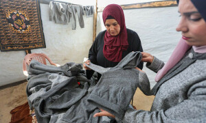 Displaced Gazans sew winter clothes from blankets