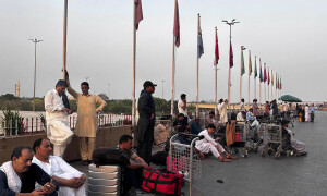 PHOTOS: Passengers wait outside Jinnah International Airport as flights put on hold