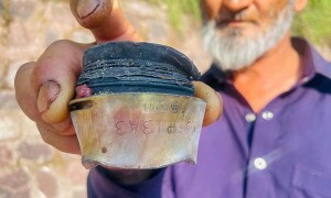 PHOTOS: A resident shows a fragment of mortar shell after cross-border shelling in AJK village near LoC