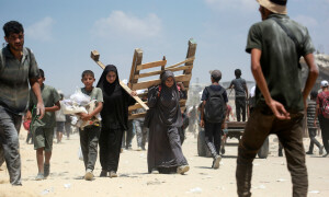 PHOTOS: Smiles, pain as Palestinians struggle through ruined terrain to secure aid