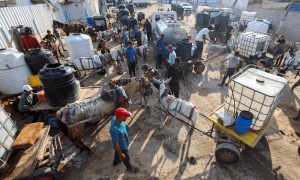 PHOTOS: Palestinians gather to collect water at distribution point amid shortages in Deir al-Balah