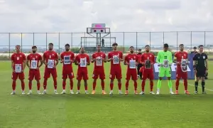 Iranian football players in Turkiye pose with photos of young war victims