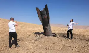 PHOTOS: Israeli man poses for pictures near missile part in occupied West Bank