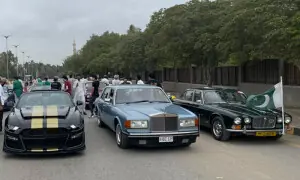 Classic cars bearing national flags drive through Karachi's streets