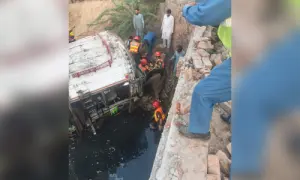 Rescue worker are seen at the site of an accident after a passenger bus plunged into a drain in Punjab's Hafizabad on Oct 29. — Photo via Rescue 1122