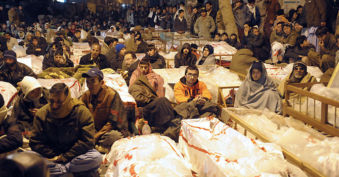 بارہ جنوری 2013 کو کوئٹہ میں شیعہ ہزارہ برادری سے تعلق رکھنے والے مظاہرین اور ہلاک ہونے والے افراد کے لواحقین میتوں کے ساتھ احتجاجی دھرنے میں موجود ہیں -- اے ایف پی تصویر