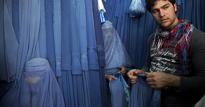 کابل: ایک دکان دار گاہک خواتین کو برقعے دکھا رہا ہے۔